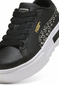 Czarne skórzane sneakersy o teksturowanej powierzchni, z wyściełanym językiem i kontrastującą białą gumową podeszwą. Posiadają złote logo PUMA oraz wzorzystą boczną wstawkę.