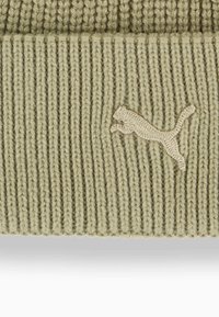 Berretto lavorato a maglia in verde chiaro con texture a costine. Presenta un logo ricamato in beige. Risvolto alla base.