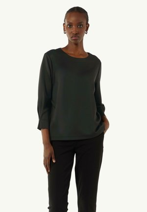 Black, long-sleeve blouse with a round neckline, soft texture, and subtle cuff details, paired with black fitted trousers.