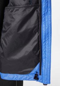 Černá prošívaná podšívka bundy s modrým lemováním, vybavená šňůrkou na stažení ve spodní části a hladkým povrchem.