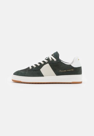 Green suede sneaker with white mesh and leather accents. Features cream laces, a gum rubber sole, and embossed logo detail. Side view.