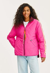 Prošívaná bunda v jasně růžové barvě se žlutými pruhy, s hnědým límcem a nastavitelnou šňůrkou. Součástí je zipové zapínání a boční kapsy.