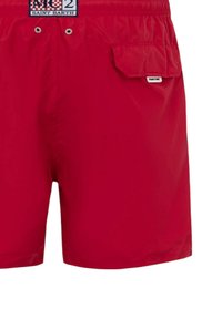 Pantaloni da bagno rossi in un tessuto leggero, con una vita elastica, tasca laterale con pattina e un piccolo logo decorativo.