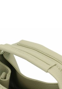 Bolso de mano de cuero gris claro con un acabado texturizado, que presenta un asa acolchada y un bolsillo interior visible en la imagen.