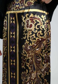 Jupe en satin avec une base noire ornée de motifs paisley dorés, bordeaux et bleus ainsi que d'accents géométriques. Texture lisse et design flottant.