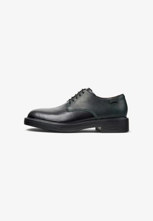Scarpe da uomo in pelle nera con punta rotonda, dettagli verde e suola in gomma testurizzata. Presentano lacci e un logo sul tallone.