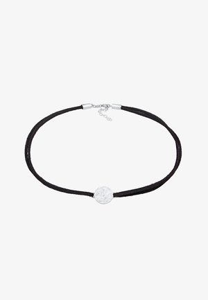 Choker en suède noir avec un pendentif rond en métal argenté. Le pendentif possède une surface texturée, tenu par des fermoirs en métal et une chaîne ajustable.
