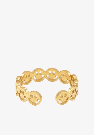 Anello in metallo dorato con una serie di motivi a faccine sorridenti interconnesse. Textura liscia, design aperto con dettagli del viso ritagliati.