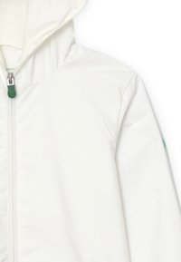 Giacca bianca con cappuccio dotata di zip completa con dettagli in verde. Tessuto liscio e leggero con un design minimalista.