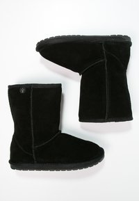 Stivali in suede neri fino al polpaccio con una texture morbida, punta arrotondata, suola robusta in gomma nera e cuciture decorative lungo le cuciture.