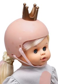 Un casco rosa con pois e un dettaglio di corona dorata si trova sulla testa di una bambola. La bambola ha i capelli biondi raccolti in una coda di cavallo intrecciata, indossando un top grigio.