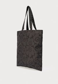 Μαύρη τσάντα ώμου με σκούρο λουλουδένιο μοτίβο, ορθογώνιο σχήμα και δύο μακριές λαβές για μεταφορά στον ώμο.