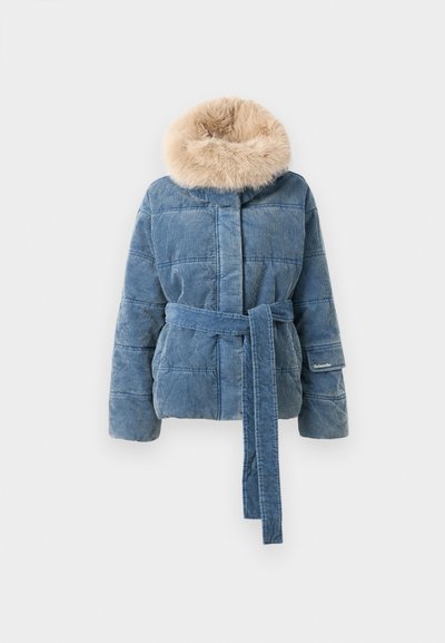 Blå quiltet jakke med et bredt bælte og krave af beige kunstpels, lavet af kordfløj, præsenteret mod en hvid baggrund.