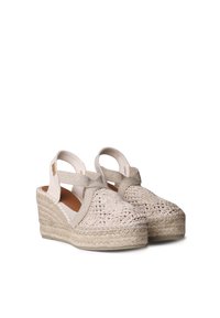 Béžové espadrilky na wedge s tkaným svrškem, elastickým popruhem a texturovanou jutovou podrážkou. Kulatý design špičky s polstrovanou stélkou.