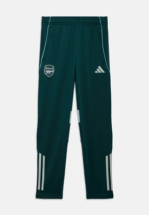 Green training pants made of synthetic material. Features Arsenal logo, Adidas logo, light blue accents, and three white stripes near the ankles.