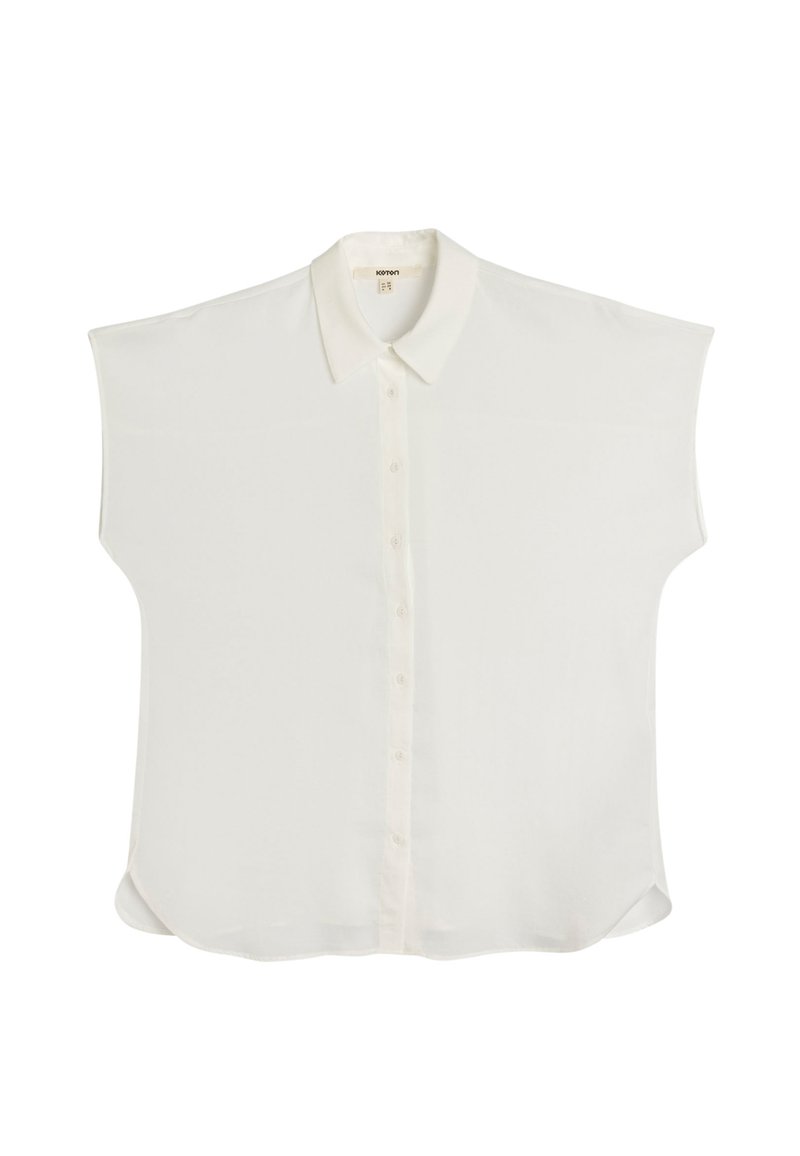 Blusa bianca a maniche corte realizzata in tessuto morbido, con chiusura a bottoni sul davanti e colletto classico. Orlo arrotondato e vestibilità rilassata.