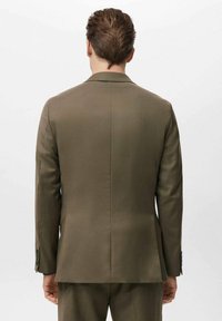 Maslinasto zelena jakna klasičnog kroja, s izraženim ramenima i glatkom teksturom. Ima jedan prorez i manžete s gumbima.