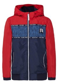 Červeno-námořnická větrovka s kapucí, s denimovými akcenty, předním zipem a žebrovanými manžetami. Obsahuje branding "BLUE RIDGE".