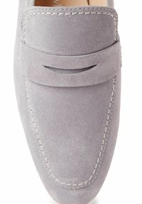 Graue Wildleder-Slipper mit einem erhöhten Nahtdesign, seitlichem Schlitzdetail und weißen Stitching-Akzenten. Runde Spitzen, glatte Textur.