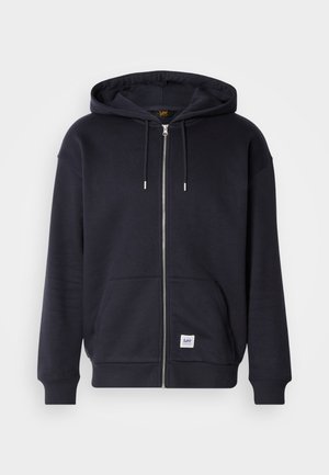 Jūras spēku zip-up kapuce izgatavota no mīkstas auduma, ar saistošu kapuci, priekšējiem kabatām un mazu Lee logotipa uzšuvumu apakšējā pusē.
