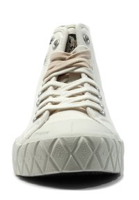 Baskets en toile blanche avec semelle en caoutchouc texturé, dotées d'œillets métalliques ronds, de lacets plats et d'une doublure à motifs. L'avant est arrondi.