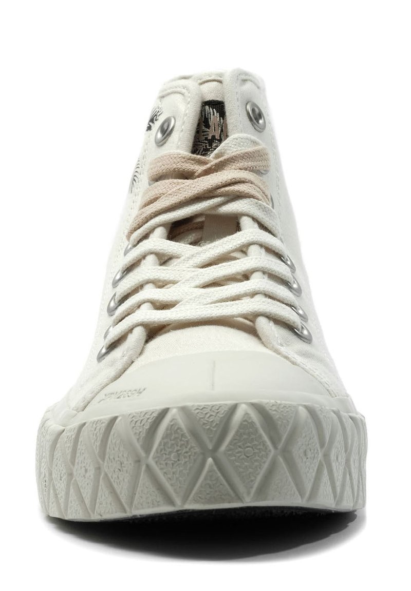 Weißer Canvas-Sneaker mit strukturiertem Gummisohle, runden Metallösen, flachen Schnürsenkeln und gemustertem Innenfutter. Die Zehenpartie ist abgerundet.