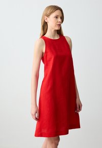 Rotes ärmelloses Kleid aus Leinen, mit rundem Ausschnitt und A-Linie. Der Stoff hat eine glatte Textur mit dezentem Glanz.