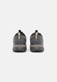 Gray athletic shoes with a mesh upper, reflective accents, and a textured sole. Features a pull tab and ergonomic design for support.