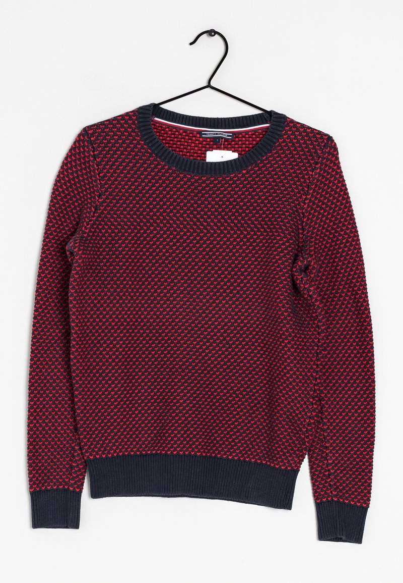 Pull bleu marine à manches longues avec motif cœur rouge, poignets et ceinture côtelés, suspendu sur un cintre noir sur fond blanc.
