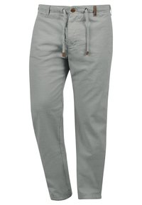Pantalon gris clair à jambe droite en tissu doux, avec une coulisse ajustable, une fermeture à bouton, et une texture lisse.