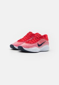 Punased sportlikud jalanõud koetatud ülaservaga, musta Nike logo, punaste paelte ja valge keskosa ning tekstureeritud musta tallaga.