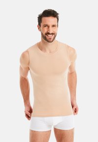 Beige sleeveless tank top made of soft fabric, displaying a slim fit and round neckline, paired with white briefs.