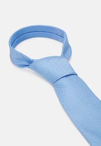 Cravate bleu clair avec une finition satinée lisse, ornée d'un motif géométrique subtil. Le design comprend une zone de nœud pour un enfilage facile.