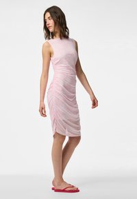 Roza haljina bez rukava s naboranim detaljima i cvjetnim uzorkom. Tkanina je lagana, poluprozirna i uska.