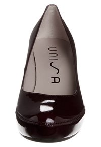 Décolleté in vernice borgogna lucida con punta affilata e dettagli di cucitura discreti. Presenta una soletta imbottita con il logo 'UNISA'.