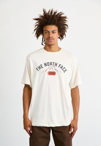 The North Face M VARSITY GRAPHIC RELAXED SS TEE - Triko s potiskem - white dune