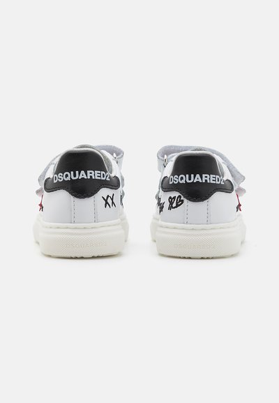 Sneaker bianco con accenti neri e dettagli ricamati. Presenta una suola testurizzata, chiusura con lacci e logo del marchio sul tallone.