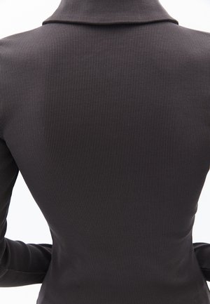 Zwarte ribstof top met een kraag, voorzien van een figure-hugging ontwerp en lange mouwen, die verticale textuurdetails benadrukt.