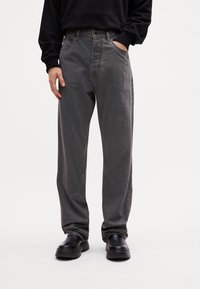 Gray denim jeans with a straight cut, five-pocket design, and button closure. Finished with subtle contrast stitching and worn texture.