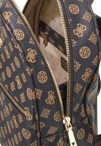 Zaino in pelle nera con stampa del logo dorata, chiusura con cerniera e foderatura beige con tasca interna con cerniera e dettaglio del logo.