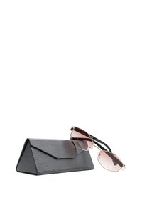 Custodia per occhiali da sole triangolare nera con texture, lenti esagonali rosa e occhiali da sole con montatura dorata appoggiati sopra.