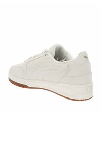 Zapatillas de ante blancas con suela de goma, punta redondeada y detalles texturizados en los laterales. Presenta costuras en contraste y acentos de logo.