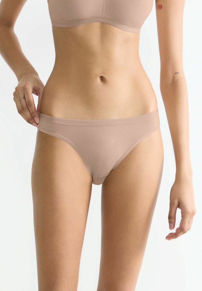 Hautfarbene Baumwollmischung-Bikiniunterhosen mit einem glatten, elastischen Bund und minimalistischer Gestaltung, ohne sichtbare Muster oder Beschläge.