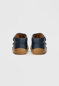 Παιδικά παπούτσια από δέρμα σε ναυτικό μπλε χρώμα, με μαλακό καφέ εσωτερικό και σόλες από καουτσούκ τύπου gum, με λουράκι βέλκρο και στρογγυλεμένο τακούνι.