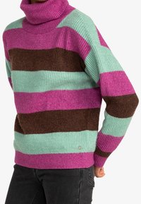 Pull en tricot avec un col roulé haut ; présente des rayures horizontales en rose, marron et vert menthe ; texture côtelée ; détail logo sur le côté.
