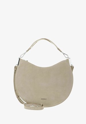 Beige suède handtas in halve maanvorm met afneembare band en zilverkleurige hardware, voorzien van een bovenhandvat en een klein merklgo aan de onderkant in het midden.