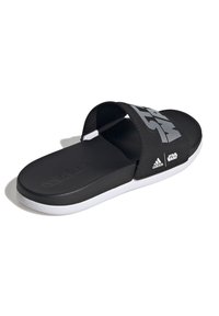 Svart slidesandal med en bred rem som har "Star Wars"- och "Adidas"-logotyper. Vit sula, texturerad fotbädd och slät remmaterial.
