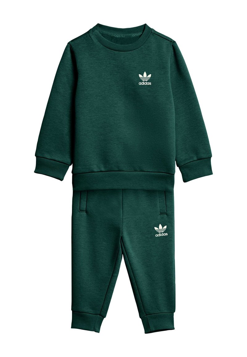 Zielony komplet dresowy z bluzy i spodni wykonany z miękkiej tkaniny, z prążkowanymi mankietami i pasem. Biały logo Adidas na piersi i boku.