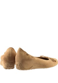 Ballerines en suède beige avec un bout rond, un accent en nœud et une semelle en caoutchouc texturé. Tige lisse et détails de couture subtils.