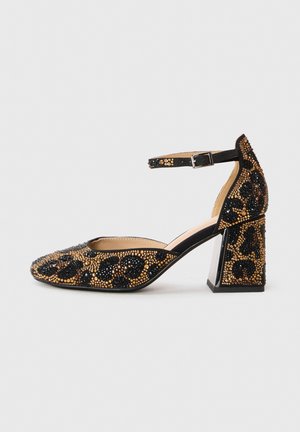 Zapato de tacón alto con diseño de leopardo en negro y dorado con cuentas. Presenta punta puntiaguda, correa en el tobillo y tacón ancho geométrico.